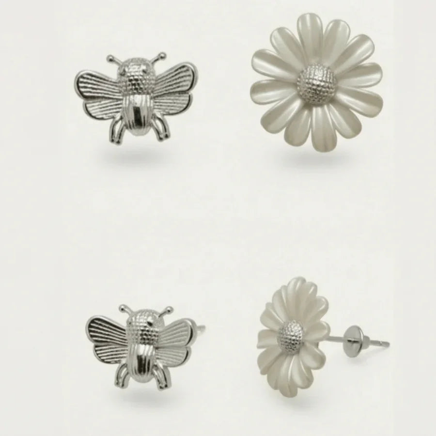 Silver bee and flower earrings on a white background
